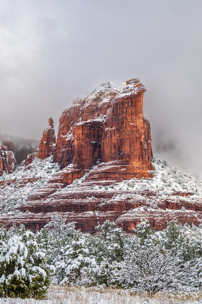 Sedona lanscape scene of a vertical view of the red rock Sugarloaf Mountain covered in snow