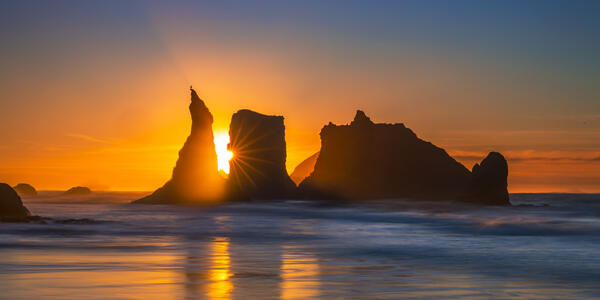 Oregon Coast landscape scene of colorful orange sky sunset above the sea stacks on Bandon Beach