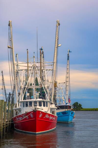 Colorful red and blue shrimp boats at a dock wairing to go out in Darien, Georgia