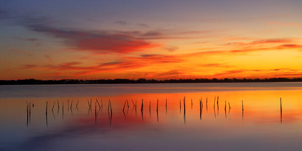 Florida landscape scene of red and yellow sunrise skies over the intercoatal waterway