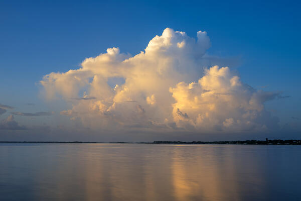 Florida landscape scene of exploding cloud at sunrise over the calm Intercoastal Waterway.