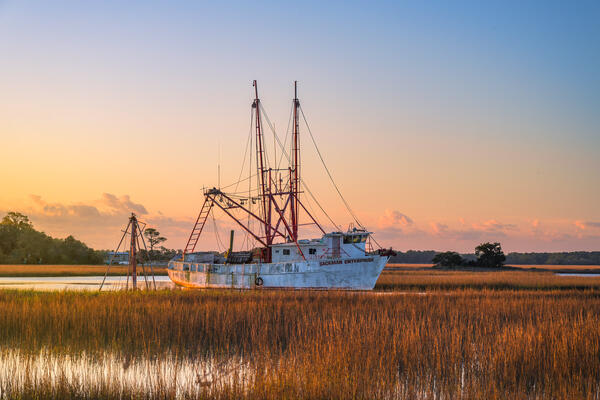 South Carolina landscape scene of a shrimp boat moored in the low country marsh at sunrise