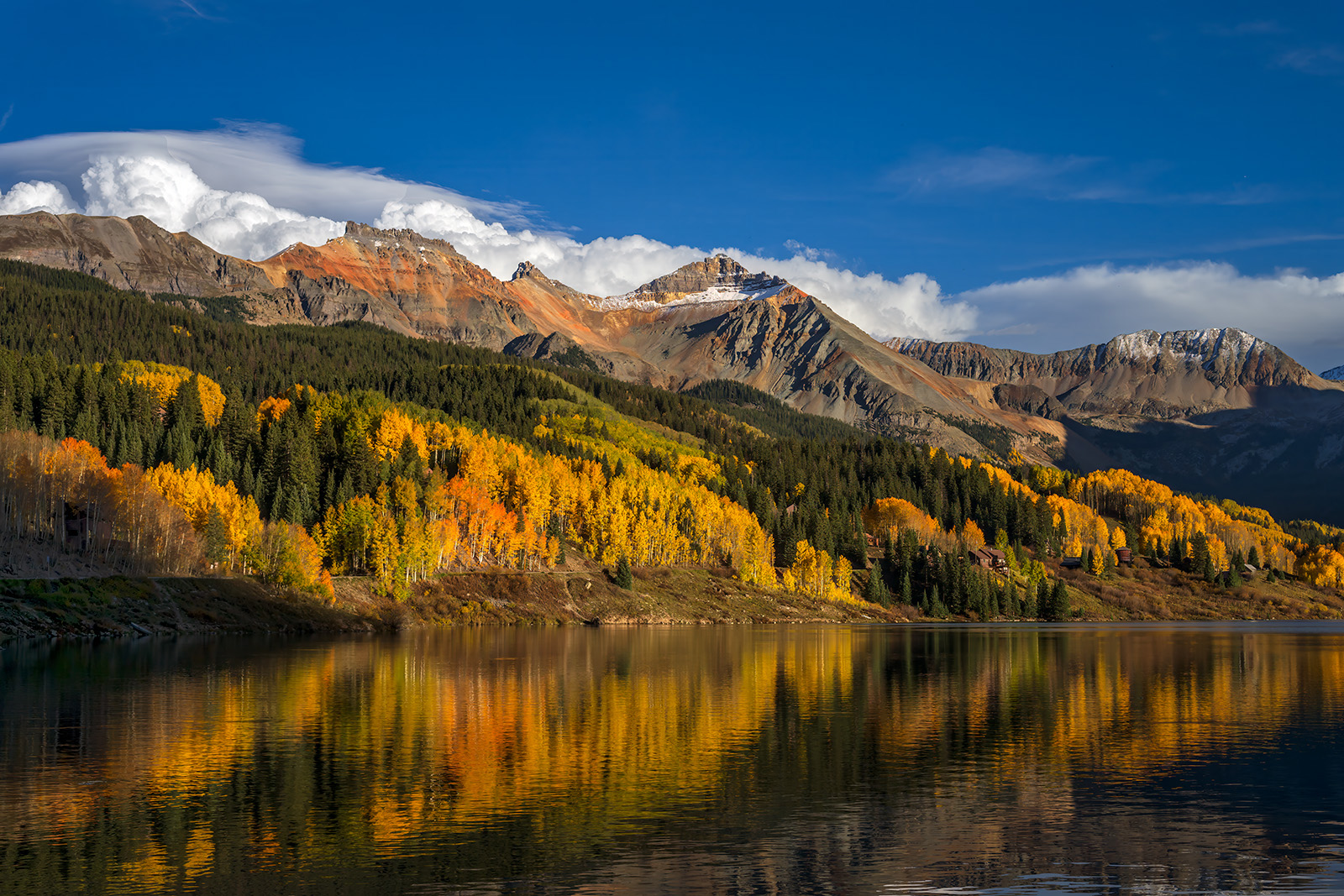 Clouds Rising Big white clouds rising behind the mountains with fall color and reflecting in Trout Lake